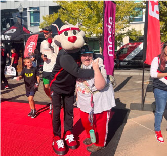 Community Rip City Rally - Blaze the Trail Blazer mascot hugging a fan.