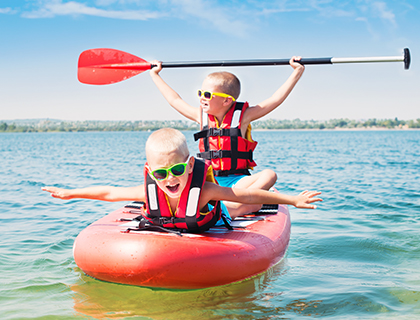Kids are out in the water in a raft after then put on sunscreen 